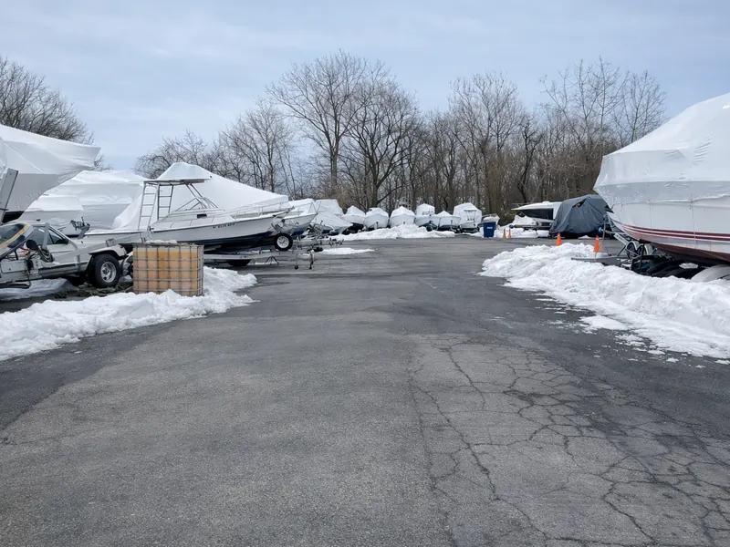 Boats in winter storage at PK Marine Service in Bristol, RI — shrink-wrapped and prepared for off-season