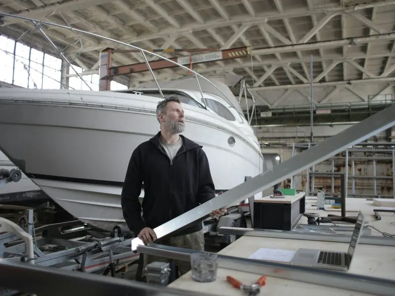 Marine technician inspecting a boat hull inside the PK Marine Service workshop in Bristol, RI